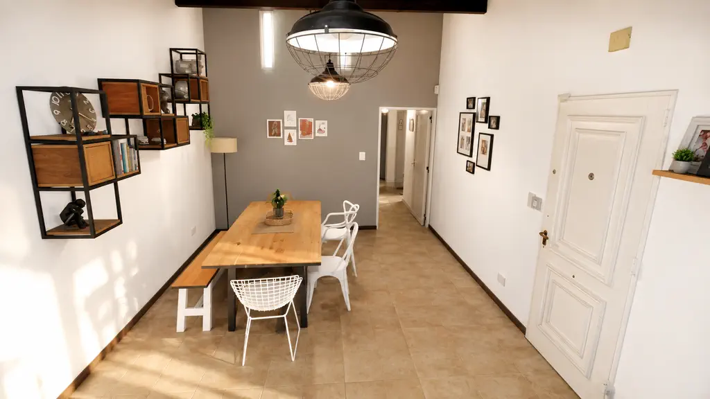 Comedor con mesa de madera, lámparas industriales y estantes de hierro y madera
