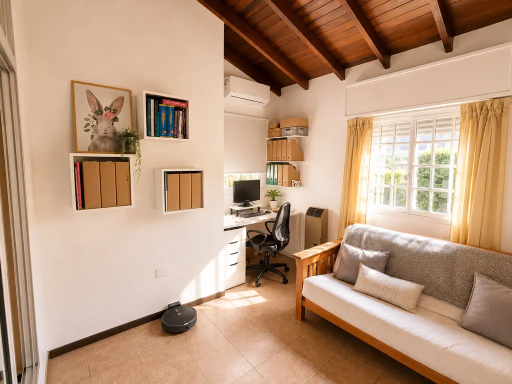 Tercer dormitorio usado como escritorio, con futón, ventana, estufa de tiro balanceado y techo de madera